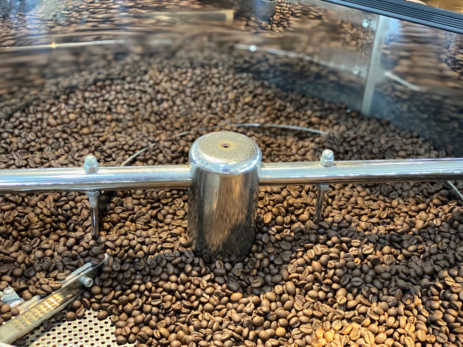 Freshly roasted beans turning in the drum of the copper coffee roaster